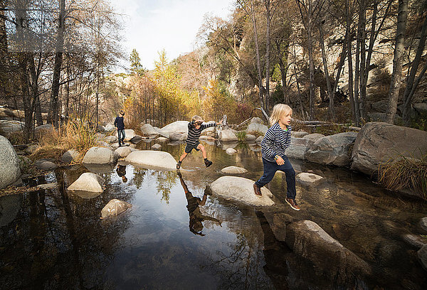 Kinder spielen auf Felsen im Fluss,  Lake Arrowhead,  Kalifornien,  USA