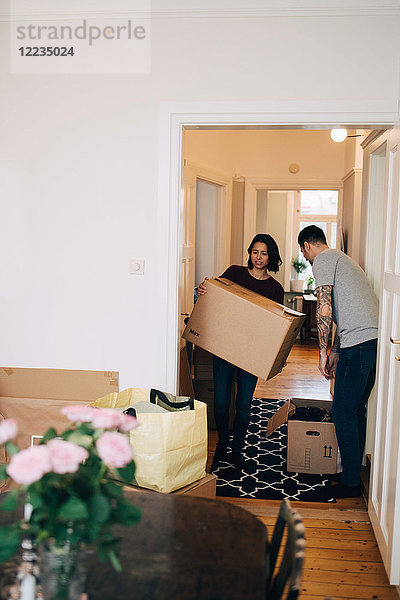 Mann und Frau mit Kisten im neuen Haus stehend