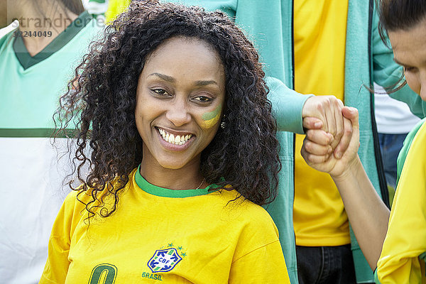 Brasilianischer Fußballanhänger lächelt fröhlich,  Porträt