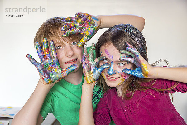 Junge und Mädchen,  Fingerfarbe auf den Händen