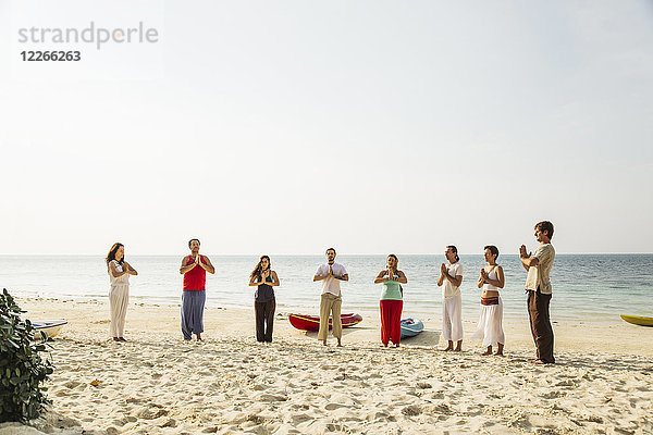 Thailand,  Koh Phangan,  eine Gruppe von Menschen,  die Yoga am Strand machen.