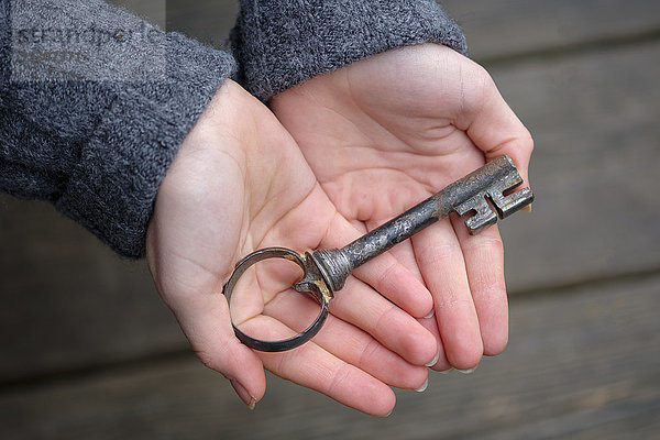 Hände halten einen alten Schlüssel,  Nahaufnahme