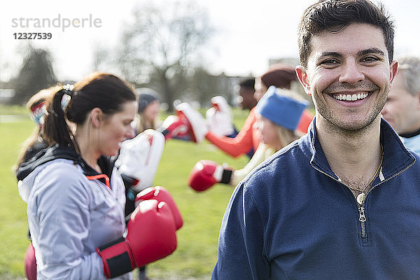 Portrait smiling,  confident young man boxing in park