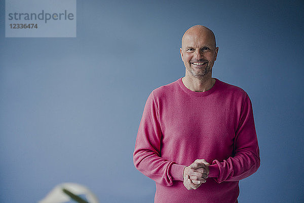 Portrait of smiling mature man wearing pink pullover