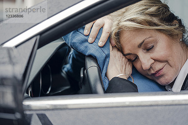 Senior businesswoman sleeping in car