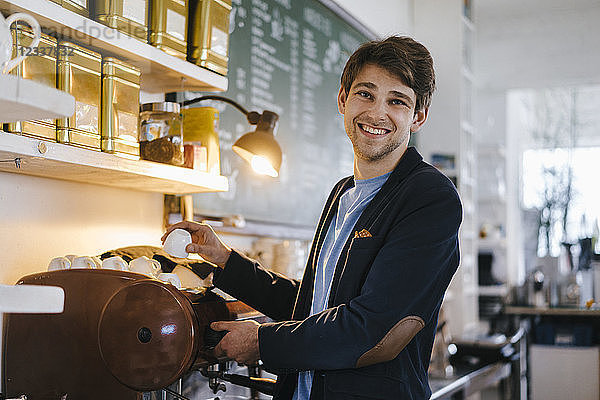 Portrait of smiling man in a cafe holding cup