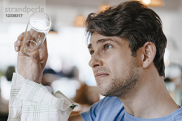 Man in a cafe examining glass
