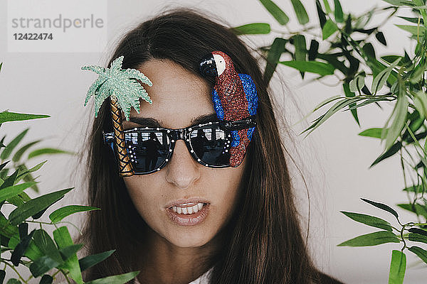 Young woman wearing exotic sunglasses with palm tree and parrot