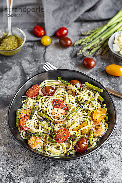 spaghetti with shrimps,  green asparagus,  tomato,  pesto and parmesan