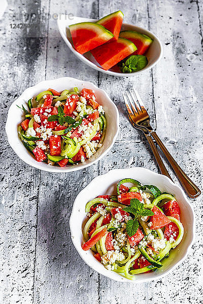 Two bowls of salad with watermelon,  cucumber,  feta and mint