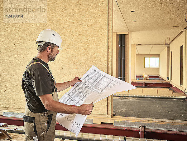 Worker with helmet holding construction plan