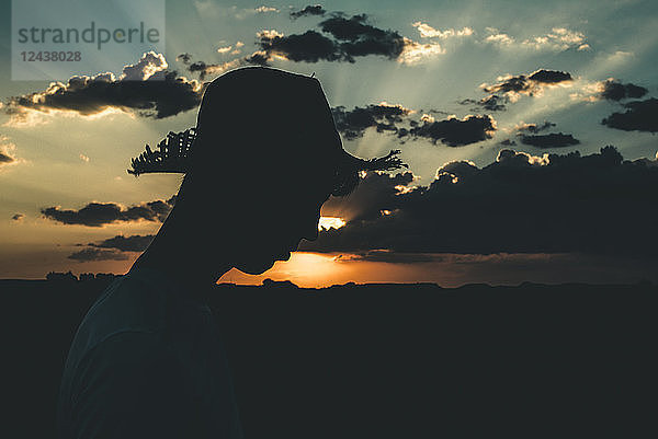 Silhouette of a young man with hat at sunset