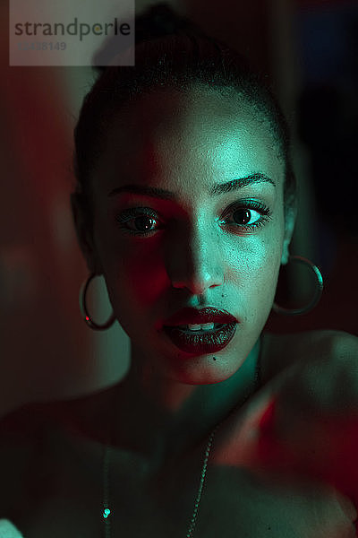 Portrait of beautiful young woman with artificial light