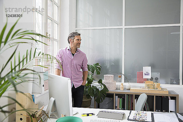 Man standing at the window in a loft office