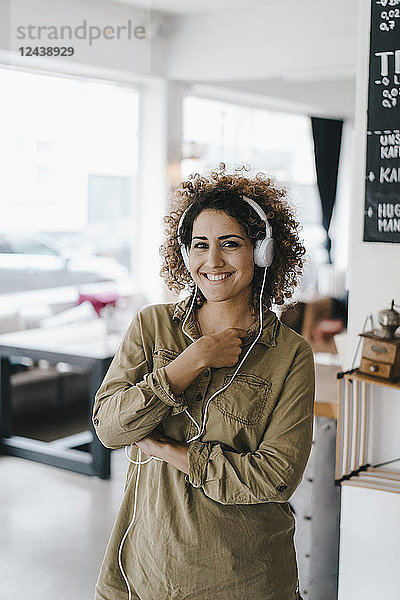 Young woman with headphones,  working in coworking space