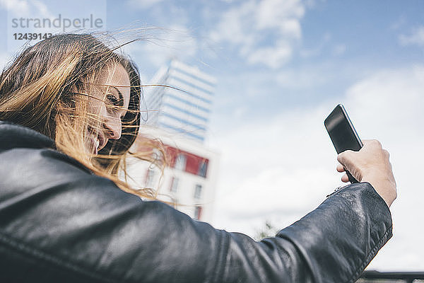 Smiling young woman taking a selfie outdoors