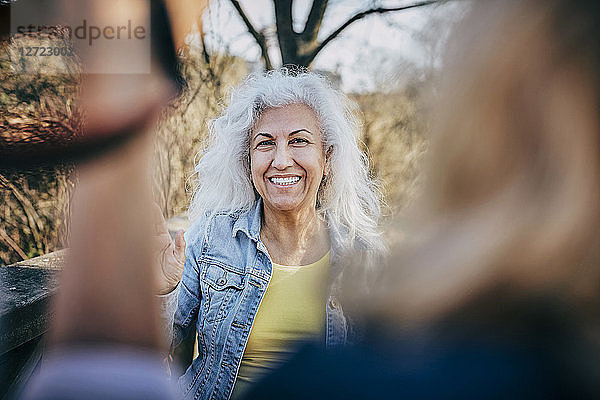 Portrait of smiling senior woman with friends at park