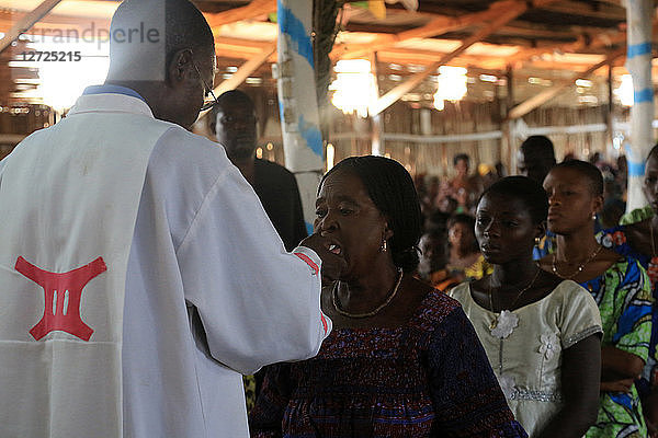 Kommunion spenden. Messe am Sonntagmorgen. Katholische Gemeinde von Koeroma. Agbonou Koeroma. Togo.
