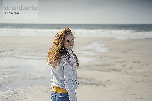 Redheaded woman relaxing on the beach,  laughing