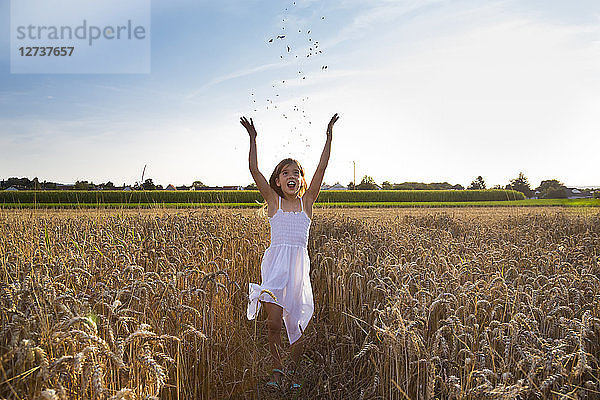 Little girl having fun in wheat field
