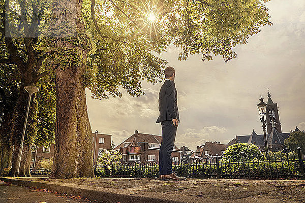 Netherlands,  Venlo,  businessman standing on pavement looking around