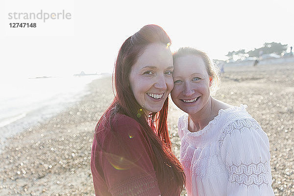 Portrait smiling,  affectionate lesbian couple on sunny beach