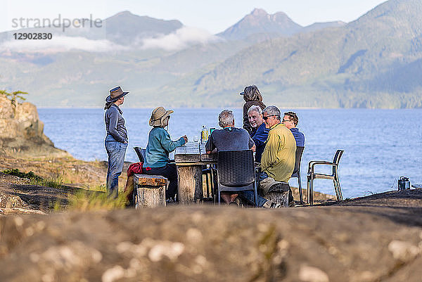 Freunde sprechen beim Abendessen am Seeufer,  Johnstone Strait,  Telegraph Cove,  Kanada