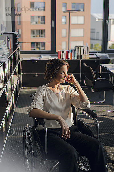 Disabled business woman sitting in wheelchair,  smiling