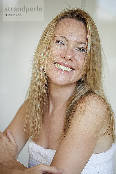 Portrait of a smiling woman,  wrapped in towel