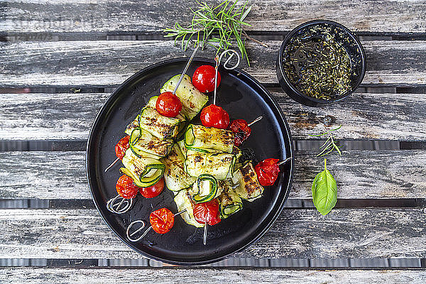 Grilled vegetarian grill skewers,  tomato,  sheep cheese and zucchini slices,  rosemary garlic oil
