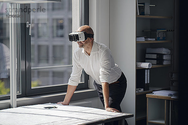 Businessman standing in his office,  using VR glasses