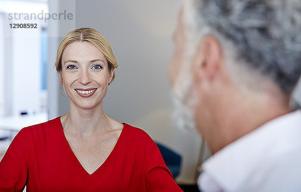 Portrait of smiling young woman with mature colleague in office