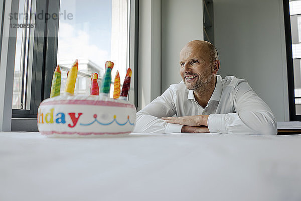 Businessman celebrating his birthday in the office,  making a wifh