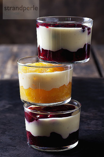 Red and yellow fruit compote with vanilla sauce layered in glasses