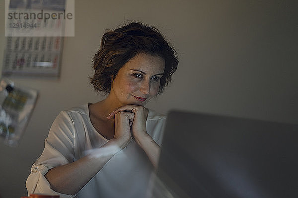 Businesswoman working overtime,  using laptop
