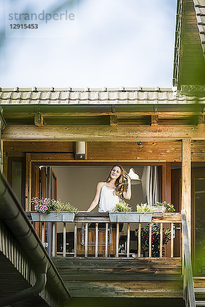 Portrait of smiling woman standing on balcony