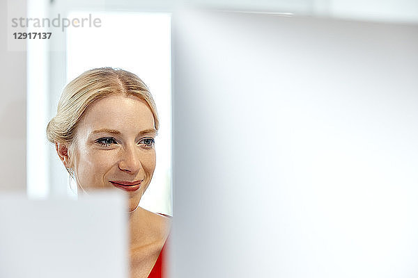 Portrait of smiling young woman working on computer