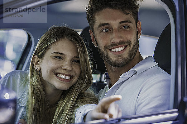 Lächelndes Paar im Auto sitzend