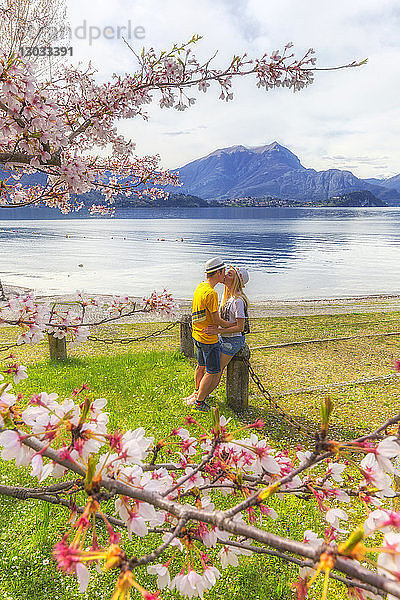 Touristenpaar küsst sich vor dem See,  Lierna,  Provinz Lecco,  Comer See,  Italienische Seen,  Lombardei,  Italien
