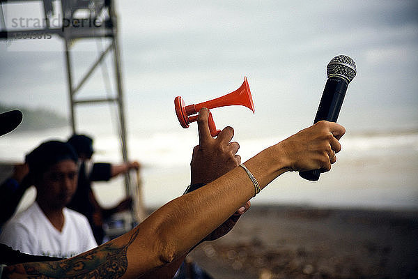 Ausgeschnittenes Bild von Personen mit Mikrofon und Sirene