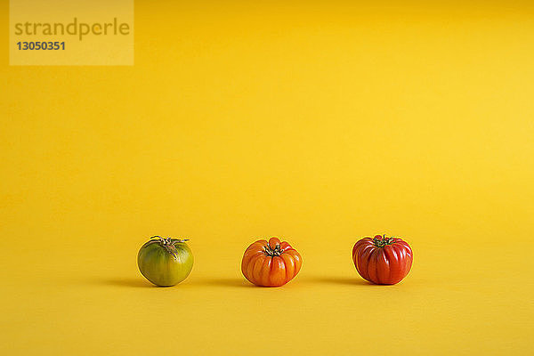 Bunte Tomaten auf gelbem Hintergrund