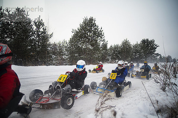 Menschen mit Freude an Gokart-Rennen auf schneebedecktem Feld