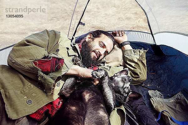 Mensch und Hund entspannen sich im Zelt auf dem Campingplatz