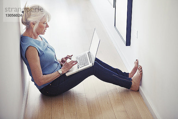 Hochwinkelansicht einer älteren Frau mit Laptop zu Hause