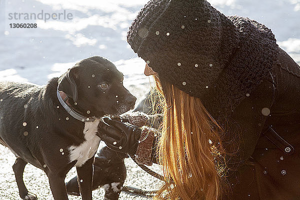 Frau mit Hund auf schneebedecktem Feld