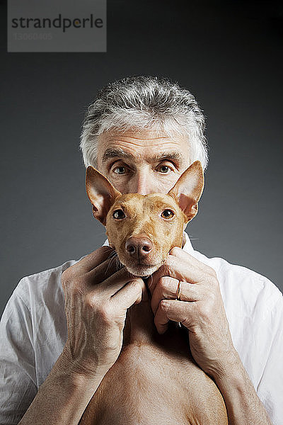 Porträt von Mensch und Hund vor grauem Hintergrund