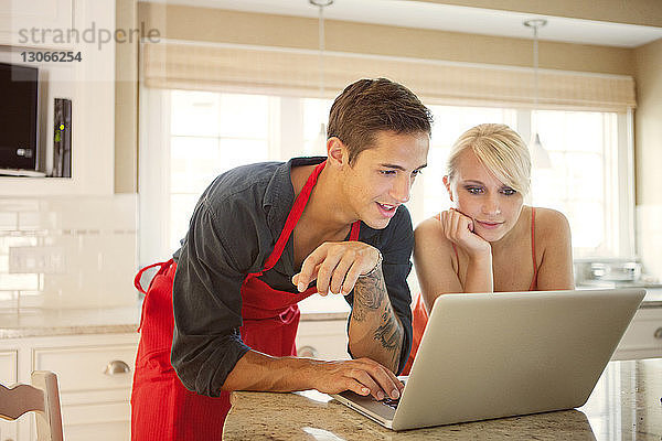 Ehepaar benutzt Laptop in der Küche zu Hause