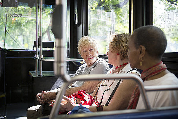 Frauen unterhalten sich während der Fahrt im Bus