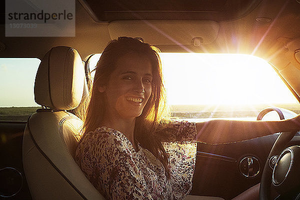 Porträt einer glücklichen Frau im Auto sitzend