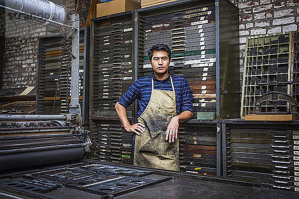 Porträt eines Arbeiters,  der in der Werkstatt an Maschinen steht